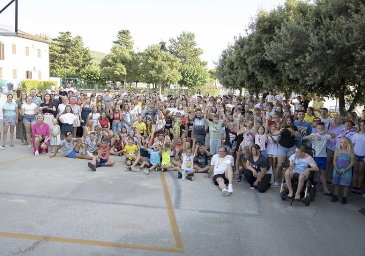 Skupinska fotografija predsednice republike Nataše Pirc Musar z otroki v letovišču Rdečega križa na Punatu.