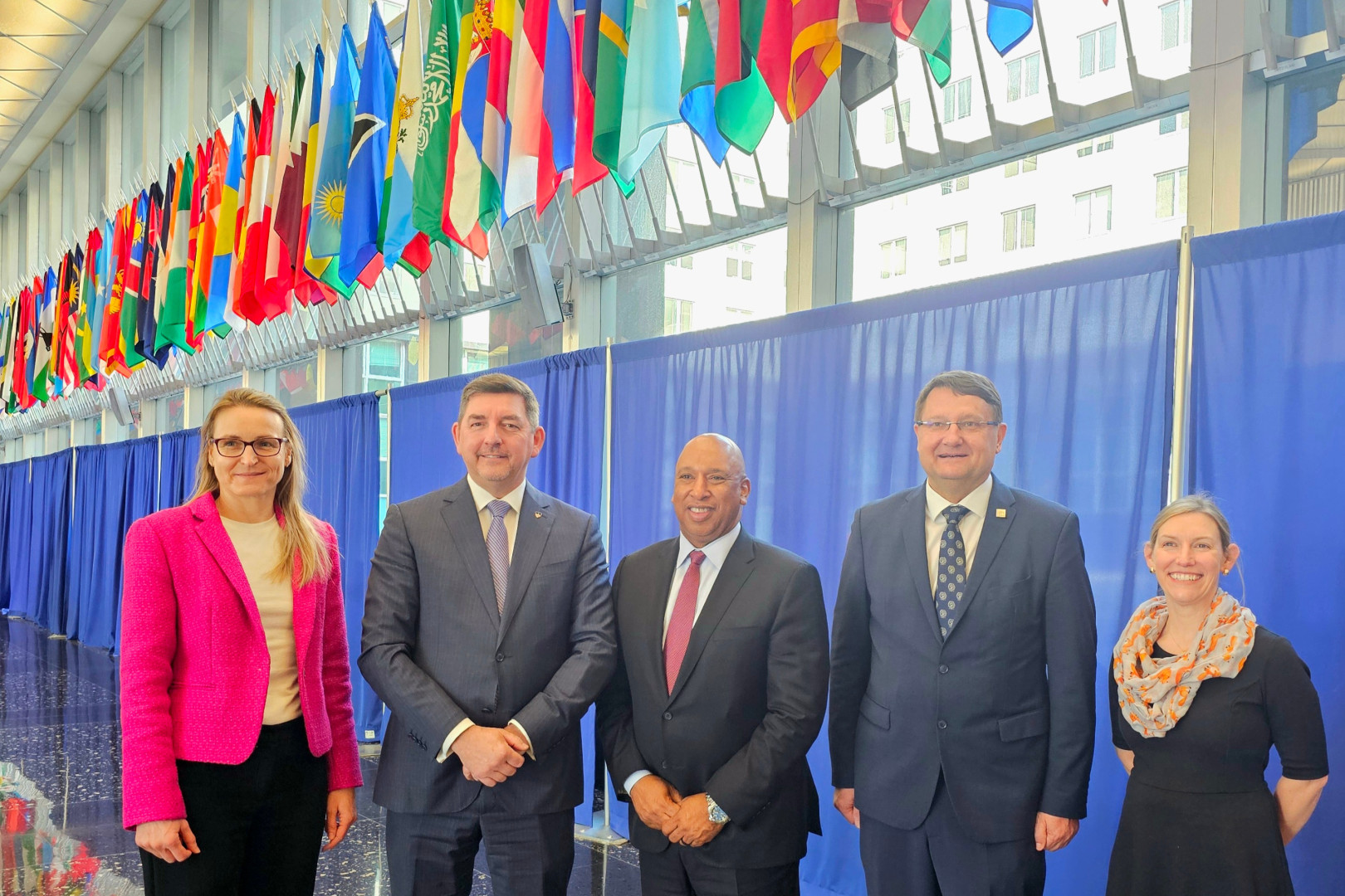 Udeleženci stojijo pod različnimi zastavami.