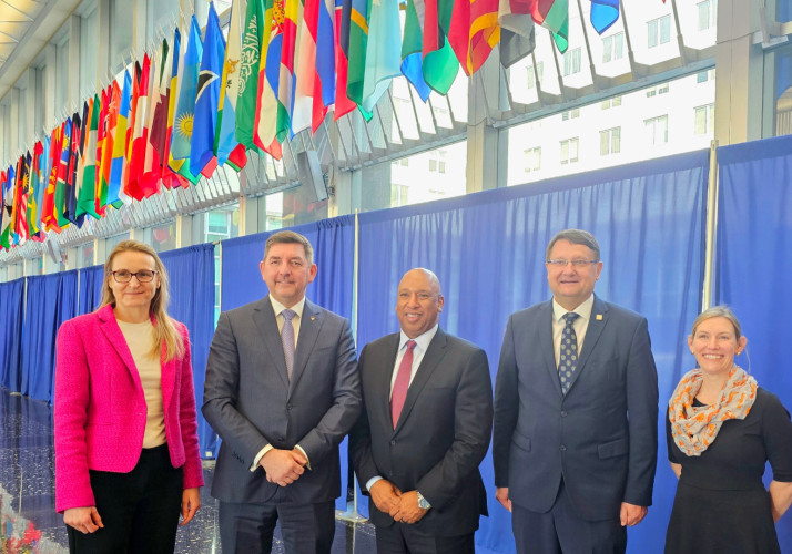 Udeleženci stojijo pod različnimi zastavami.