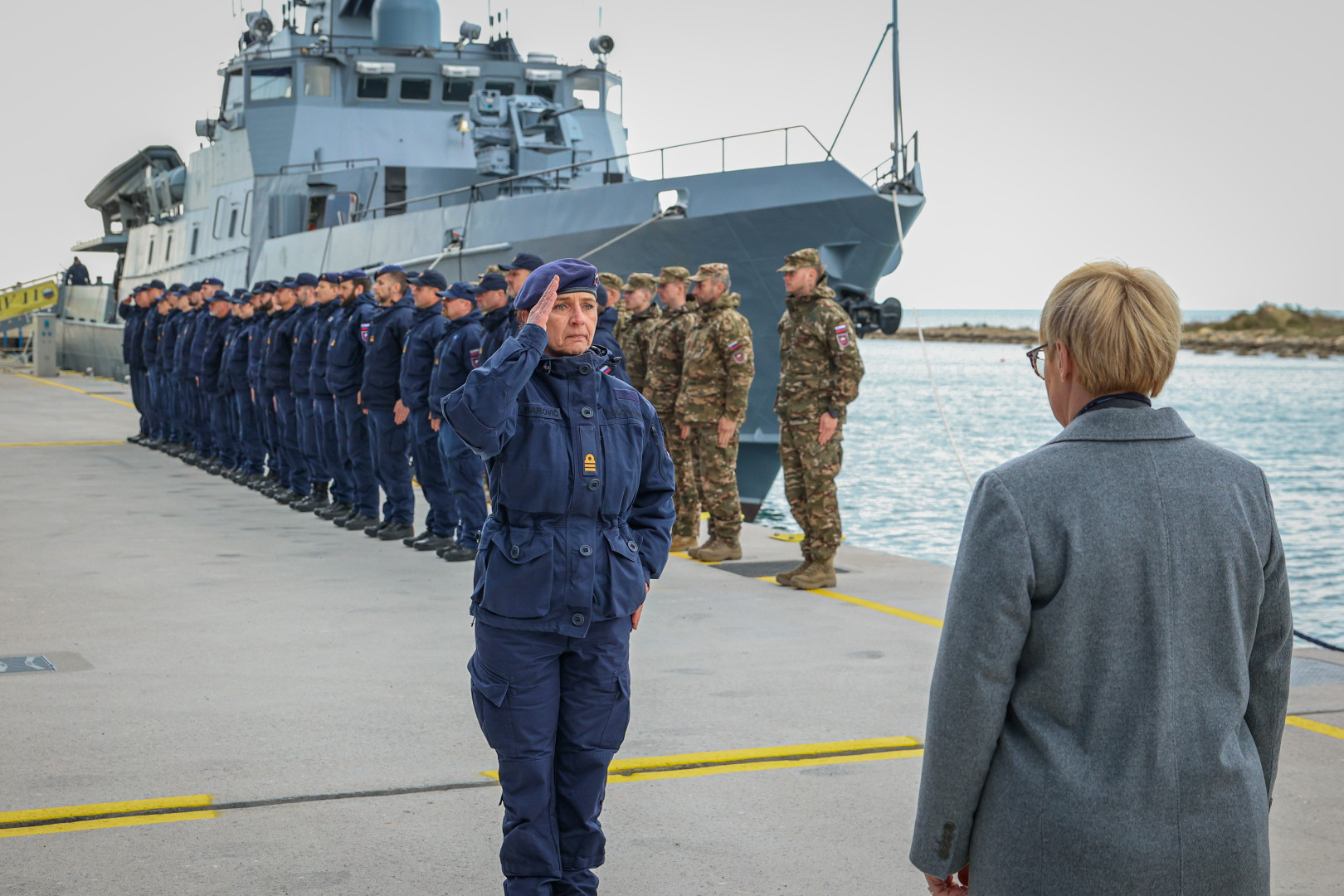 Predsednica stoji pred poveljujočo častnico na privezu pred ladjo Triglav.