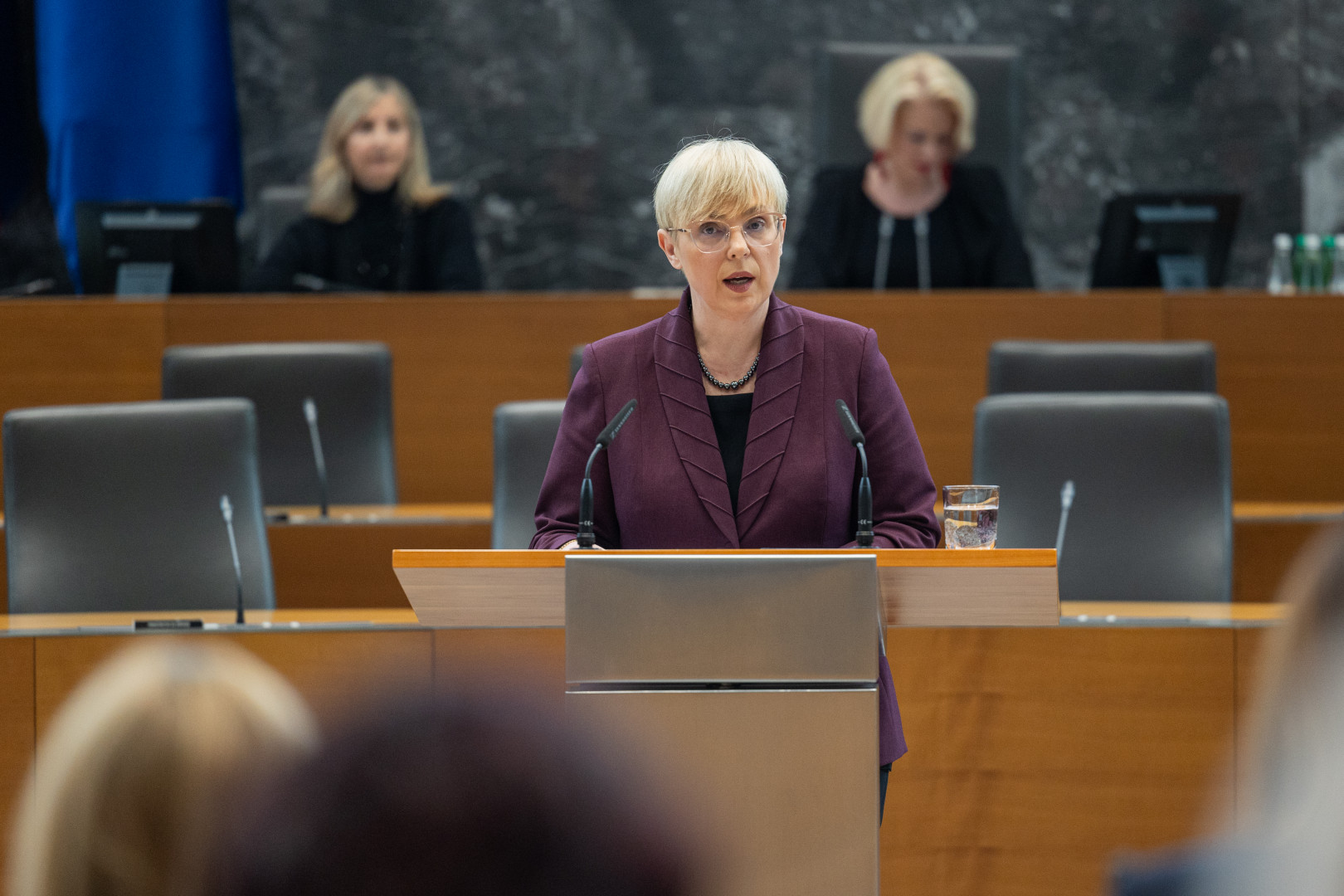 Predsednica v Državnem zboru za govornico nagovarja poslance. V ozadju predsednica Državnega zbora RS.
