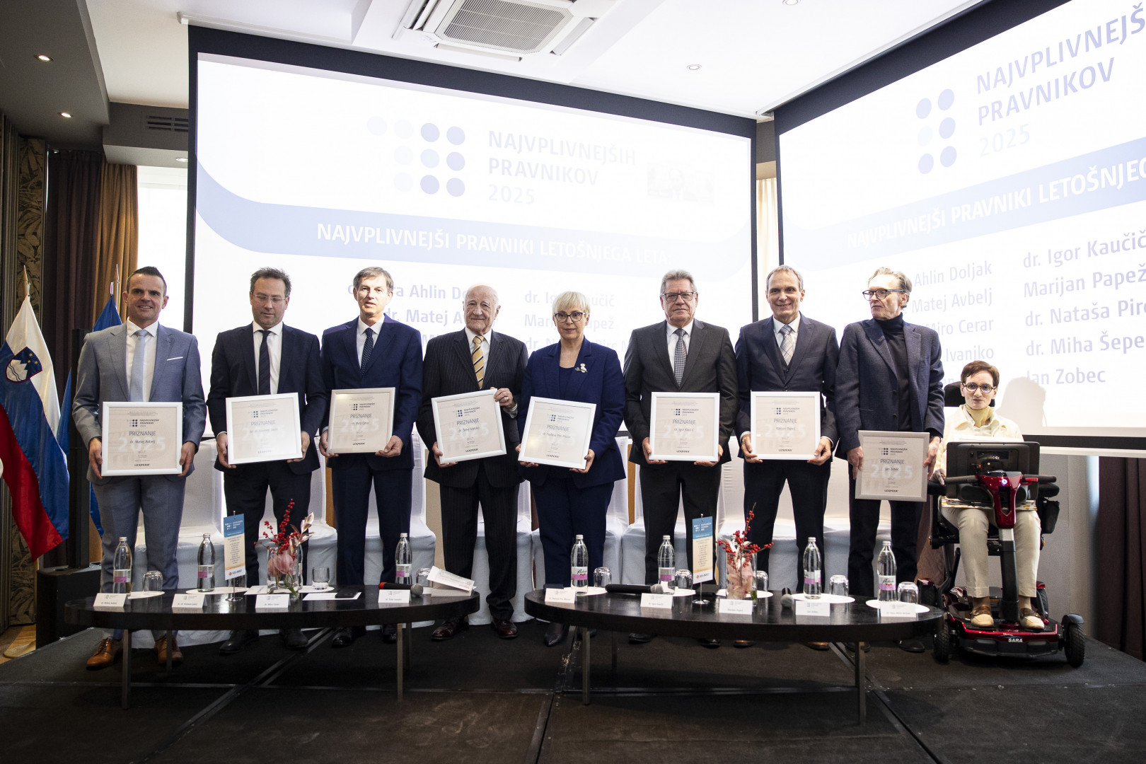 Predsednica in devet drugih v rokah drži priznanje za najbolj vplivnega pravnika leta.