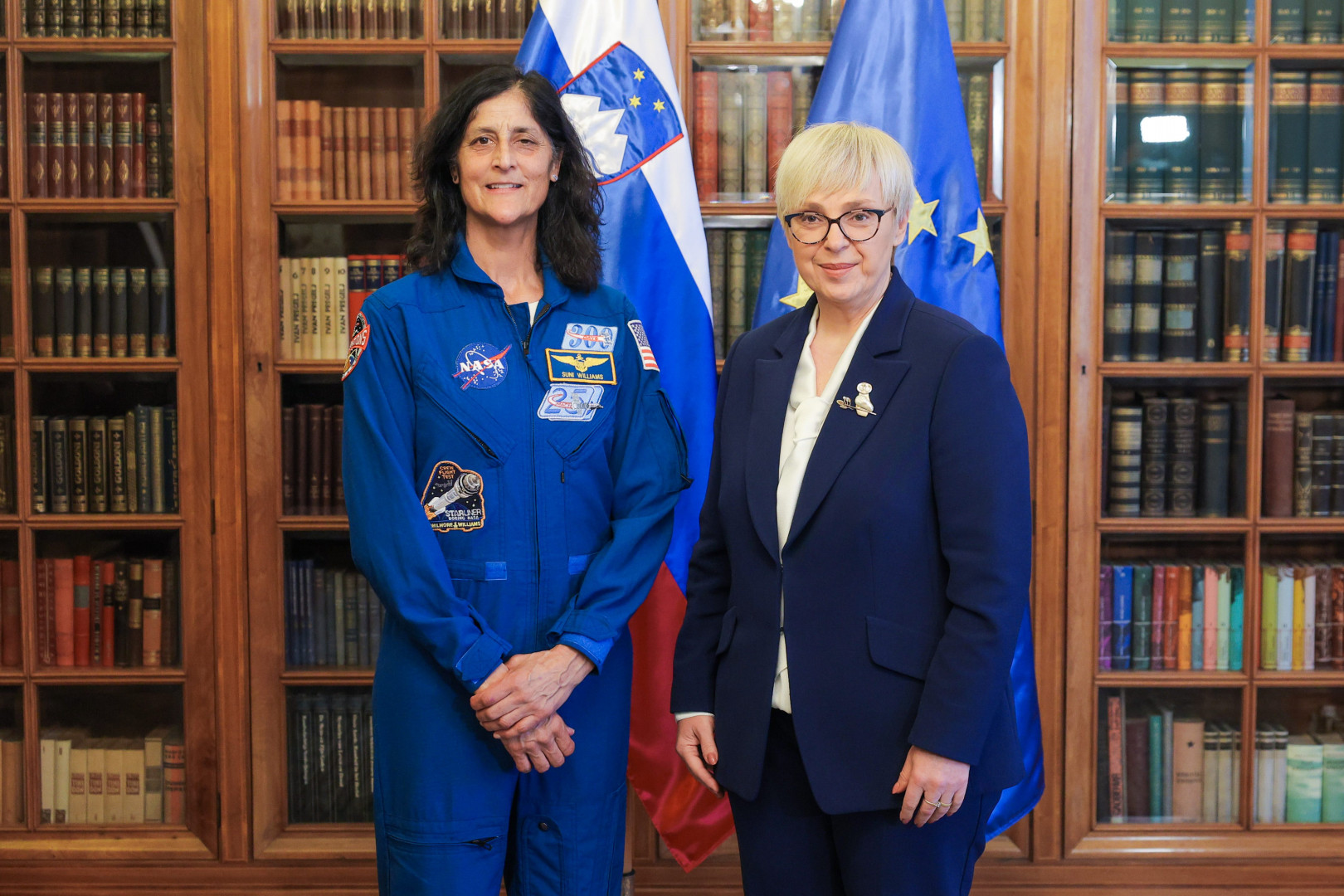 Predsednica in Sunita Williams pred zastavama.