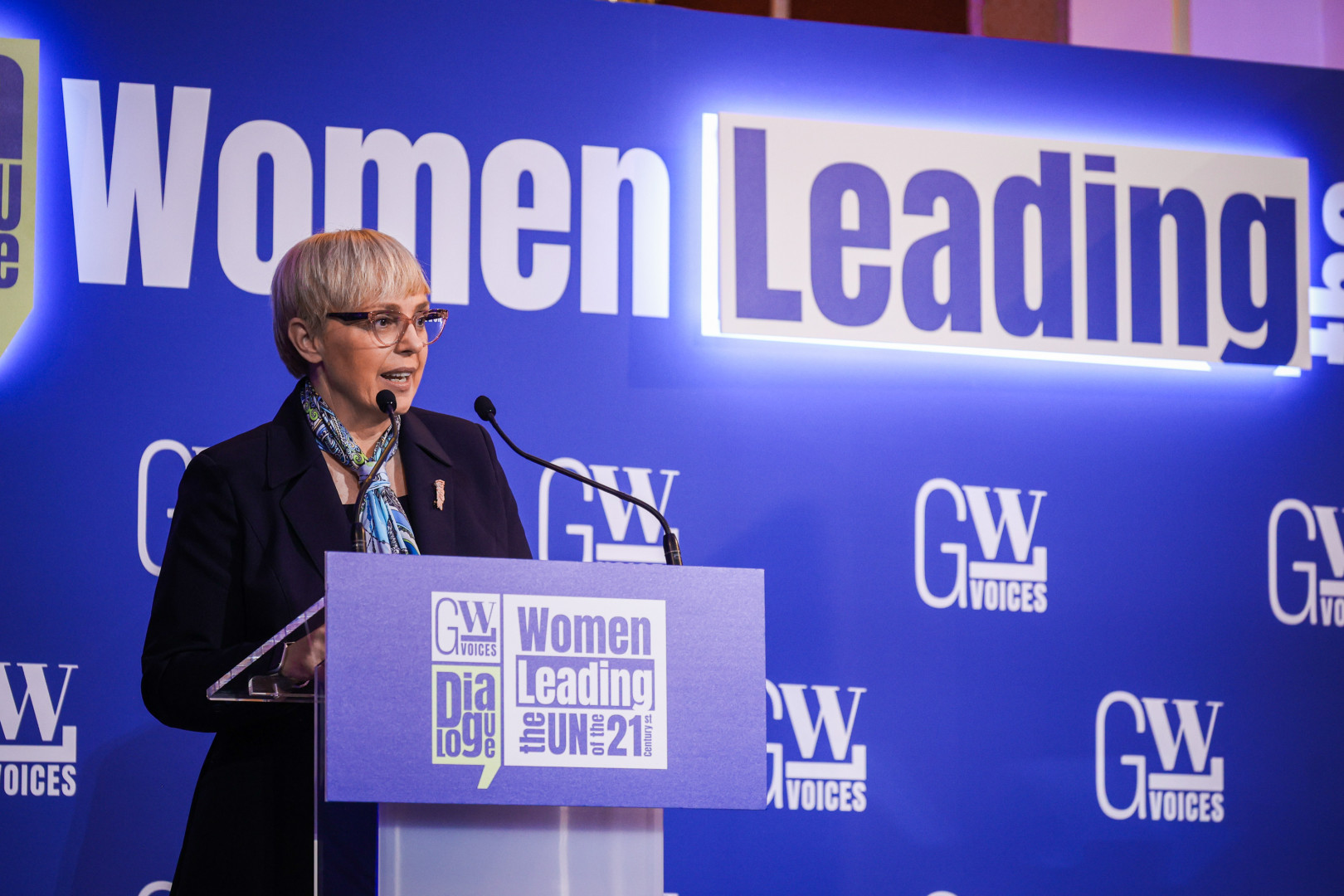 Predsednica nagovarja zbrane izza govornice, na kateri je napis Women Leading the UN.