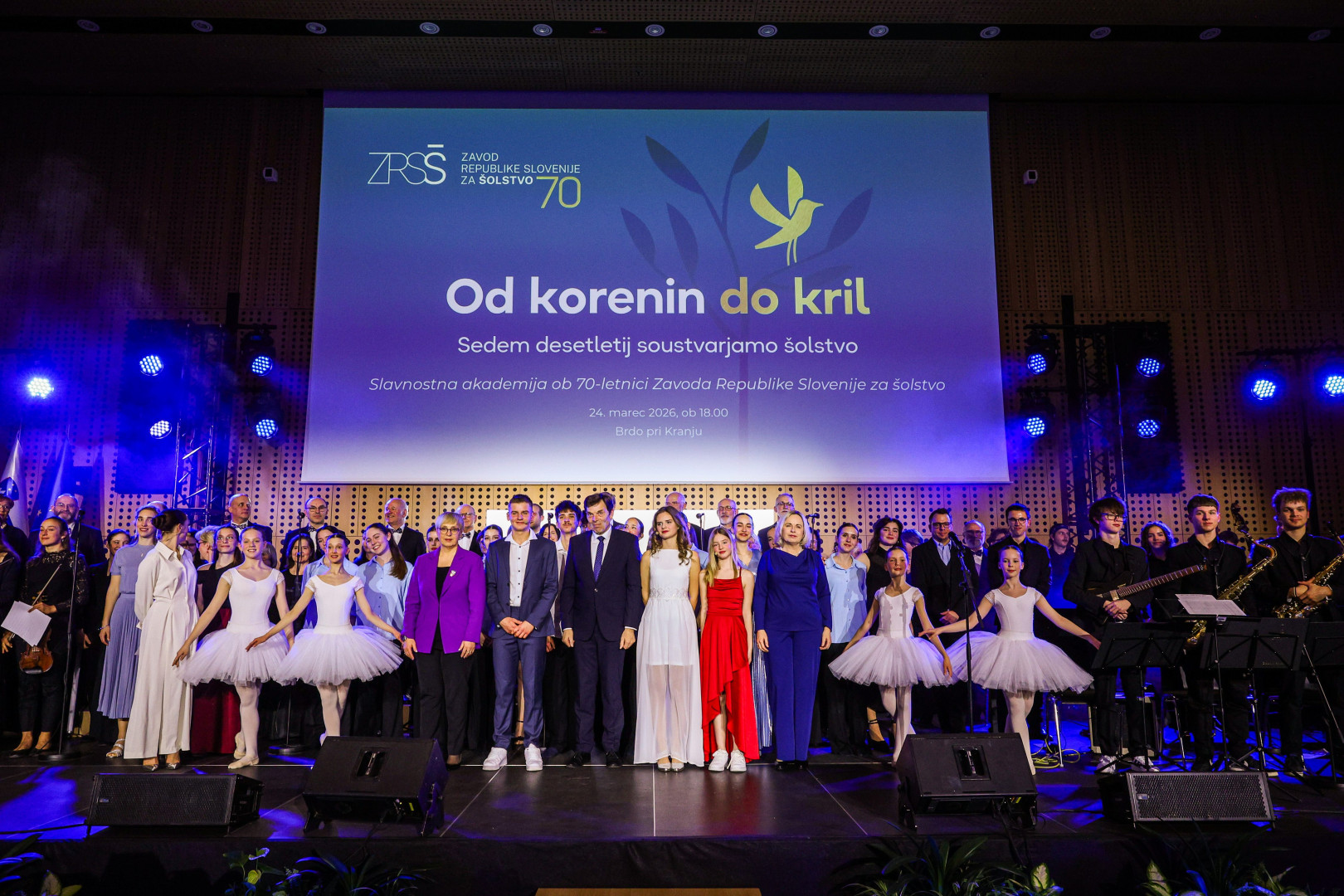 Skupinska fotografija vseh nastopajočih na odru, med njimi predsednica.