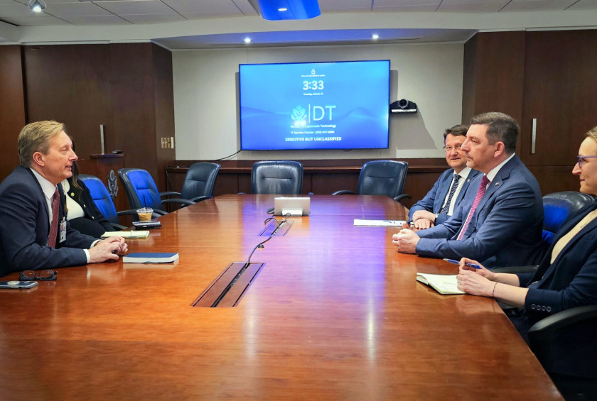 Srečanje delegacij za konferenčno mizo v uradnem prostoru z zaslonom v ozadju.