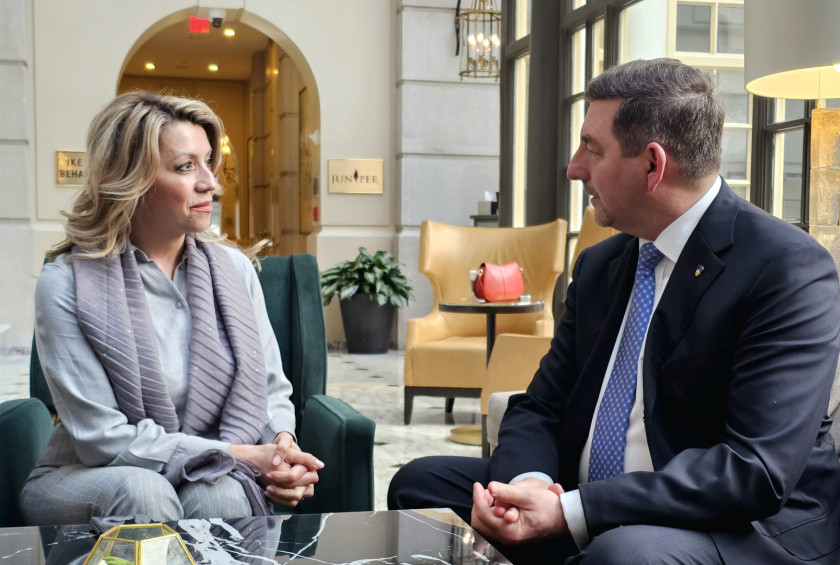 Pogovor dr. Musarja in soproge predsednika vlade Severne Makedonije. v hotelskem salonu ob oknu.