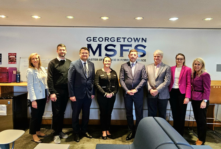 Večja skupina ljudi stoji v notranjem prostoru pred napisom Georgetown MSFS.