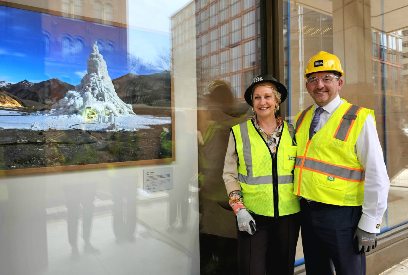 Dr. Musar in gospa v zaščitnih jopičih in čeladah stojita ob fotografiji ledene pokrajine.