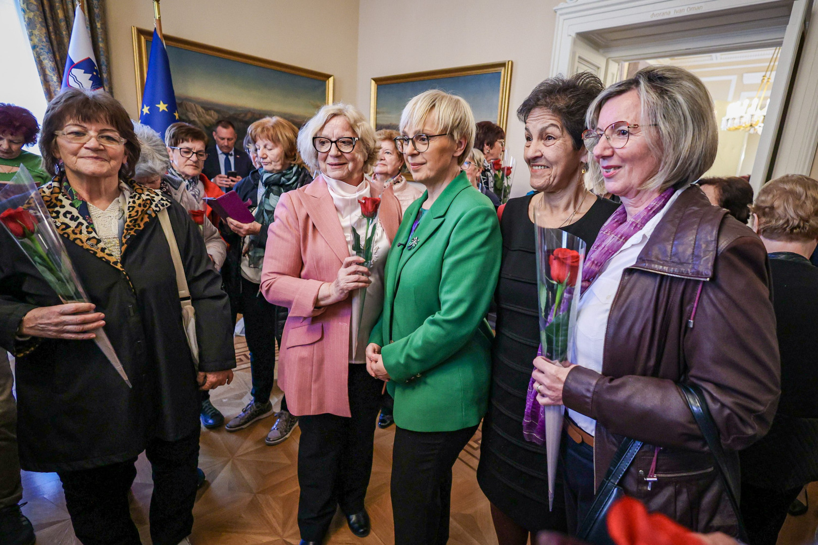 Predsednica se fotografira z obiskovalkami palače v svoji pisarni.