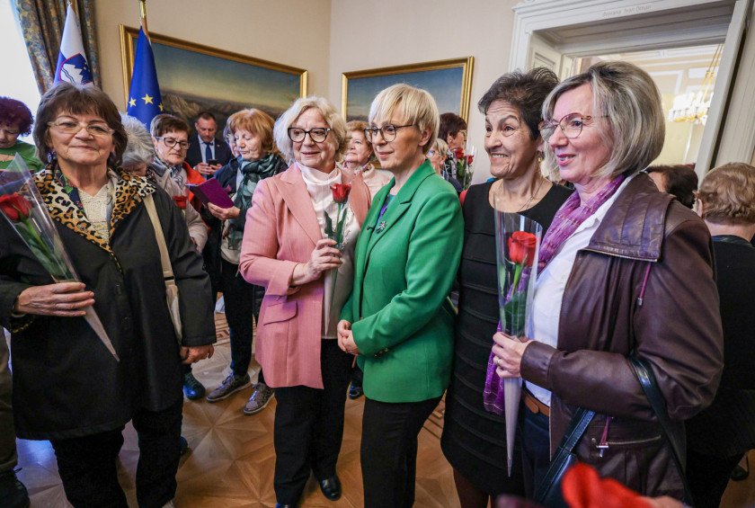 Predsednica se fotografira z obiskovalkami palače v svoji pisarni.