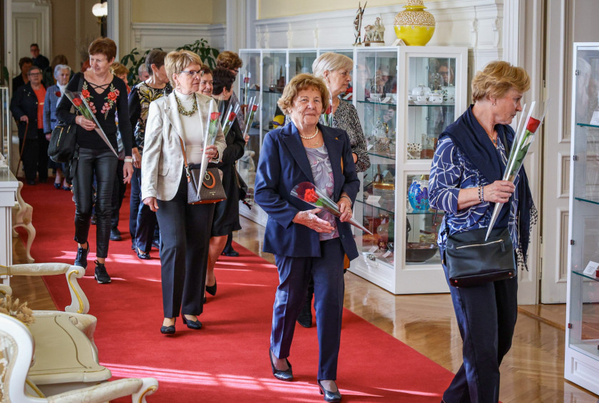 Ženske na hodniku z darili, prihajajo v pisarno predsednice.