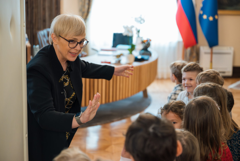 Predsednica ob vhodu v pisarno daje petko otrokom.