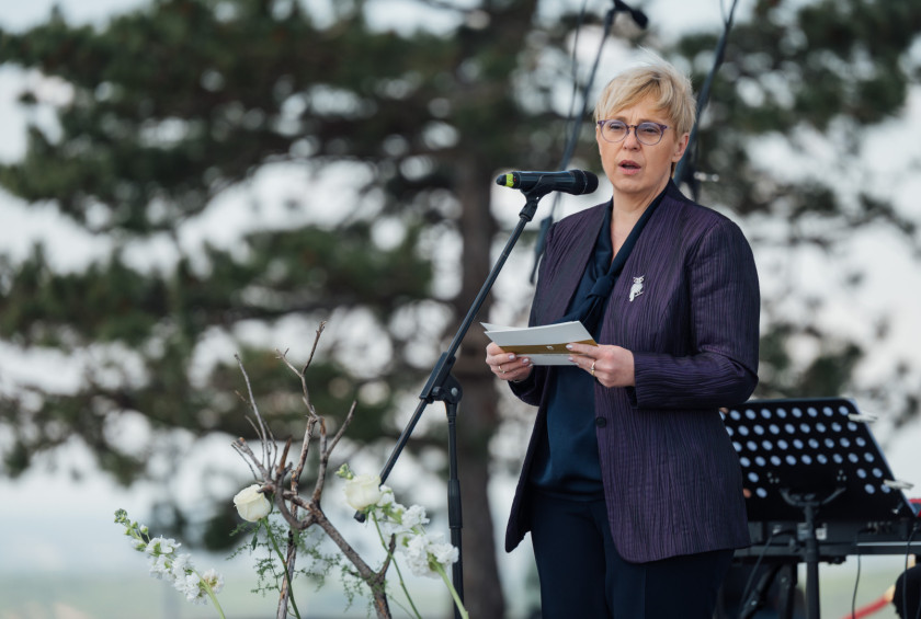 Predsednica ima nagovor za mikrofonom na dogodku.