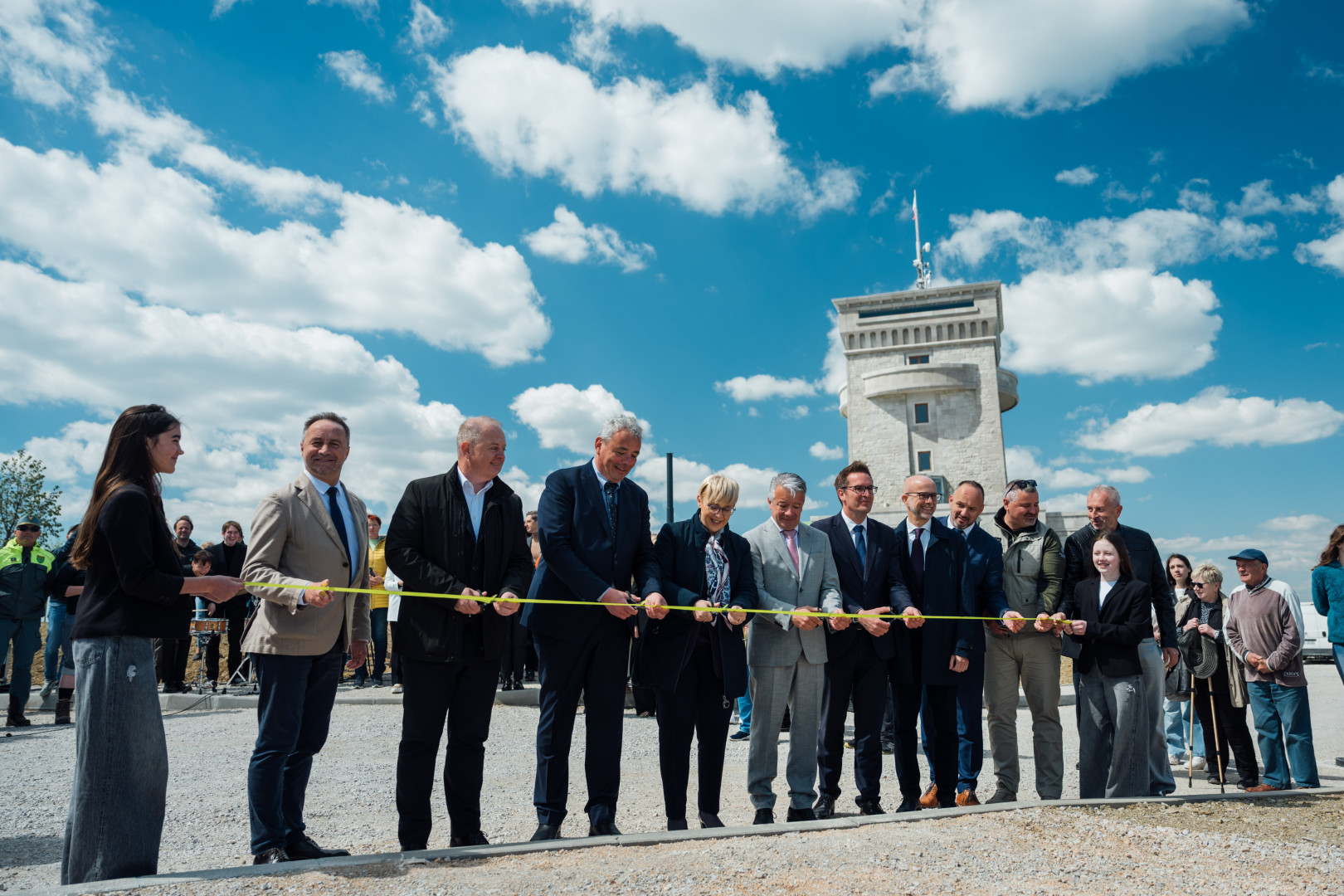 Skupinsko prerezovanje traku ob odprtju na prostem.