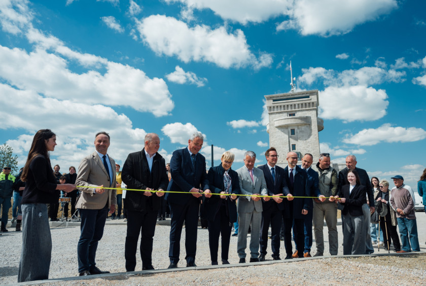 Skupinsko prerezovanje traku ob odprtju na prostem.