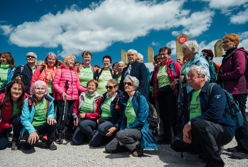 Skupinska fotografija pohodnikov na sončen dan na razgledni točki.