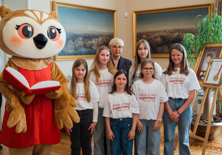 Predsednica s Sovico Karlo in osnovnošolkami, ki rade berejo.