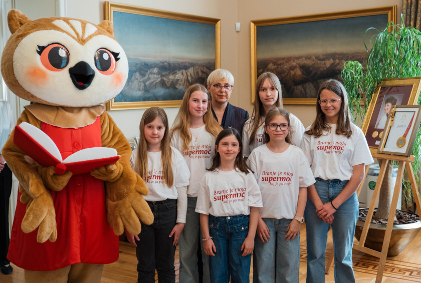 Predsednica s Sovico Karlo in osnovnošolkami, ki rade berejo.