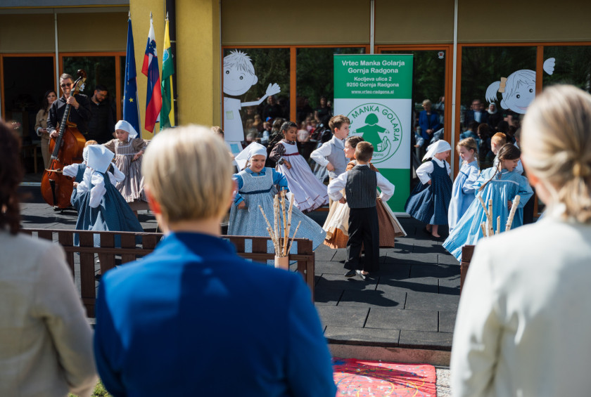 Predsednica republike spremlja nastop otroške folklorne skupine.