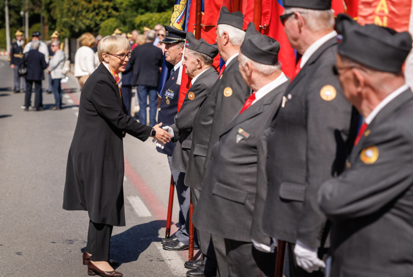 Predsednica se rokuje z nosilci praporjev.