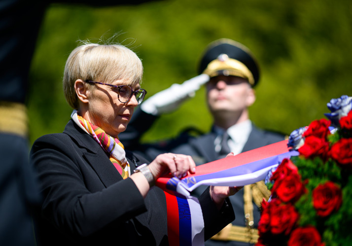 Predsednica popravlja trak na vencu.