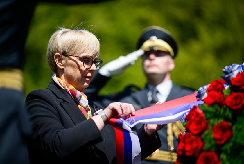 Predsednica popravlja trak na vencu.