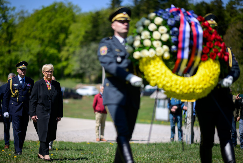 Predsednica stopa za gardistoma, ki nosita venec.