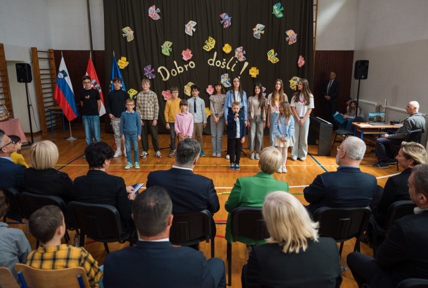 Nastop učencev osnovne šole, ki ga spremljajta oba predsednika in drugi udeleženci dogodka.