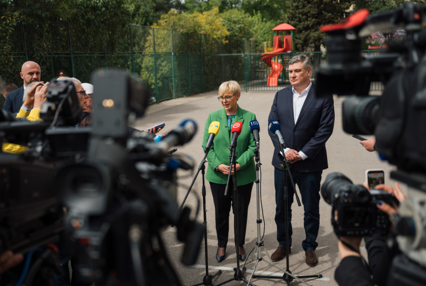 Predsednik in predsednica stojija pred mikrofoni in za številne medije podajata izjavo.