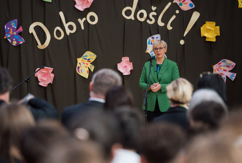 Predsednica stoji na odru, v ozadju je na odru na črni tkanini napis Dobro došli !