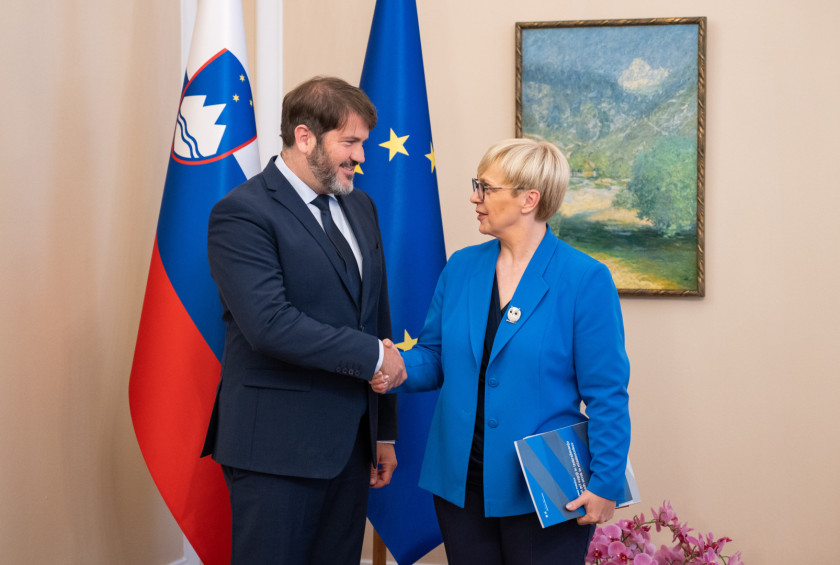 Zagovornik načela enakosti in predsednica republike se rokujeta.