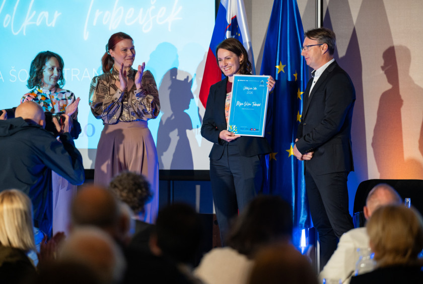 Prejemnica priznanja v roki drži diplomo.