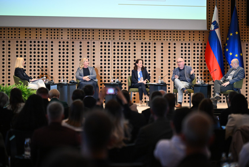 Panelisti drugega panela na forumu sedijo na odru in razpravljajo.