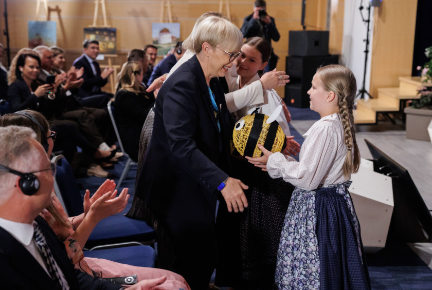 Plesalka iz folklorne skupine iz Osnovne šole Tabor I Maribor predsednici republike podajajo spominek; čebelo. 