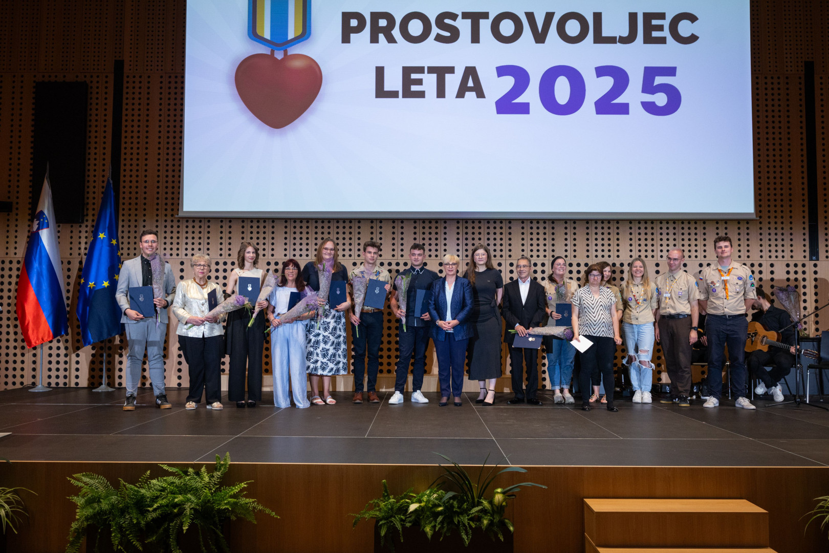 Skupinska fotografija razglašenih prostovoljcev leta 2025 s predsednico republike in predsednico Mladinskega sveta Slovenije Evo Kotnik. 