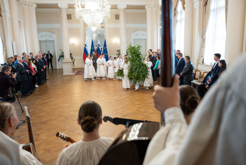 Obiskovalci v narodnih nošah plešejo in igrajo v Veliki dvorani.