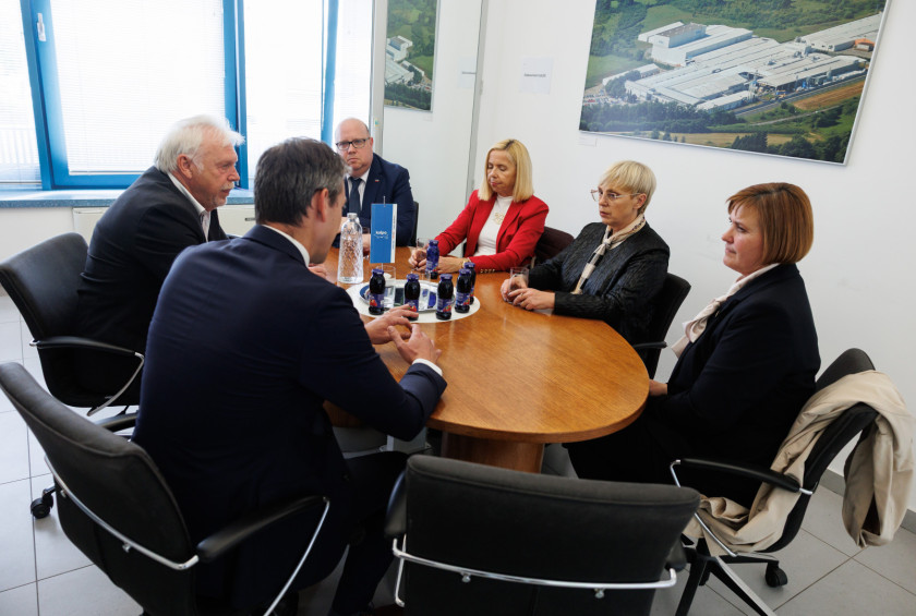 Predsednica s sogovorniki sedi za mizo.