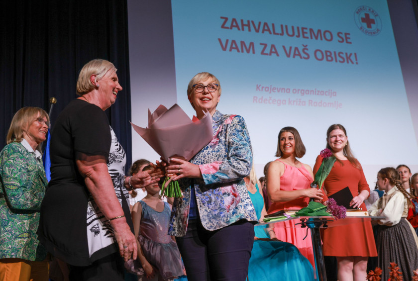 Predsednica republike prevzema šopek, ki so so ji ga kot presenečenje ob bližajočem se rojstnem dnevu podarili organizatorji dogodka. 