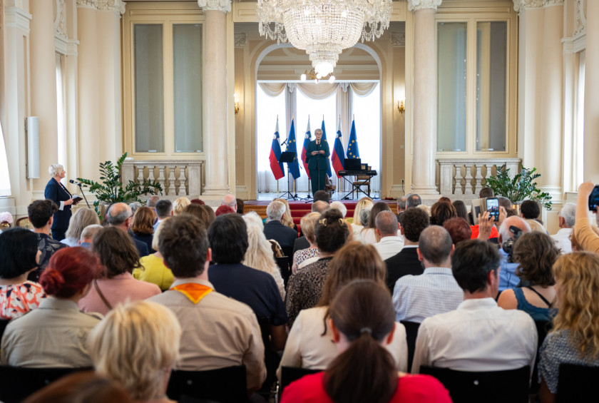 Pogled na polno veliko dvorano in predsednico na odru.