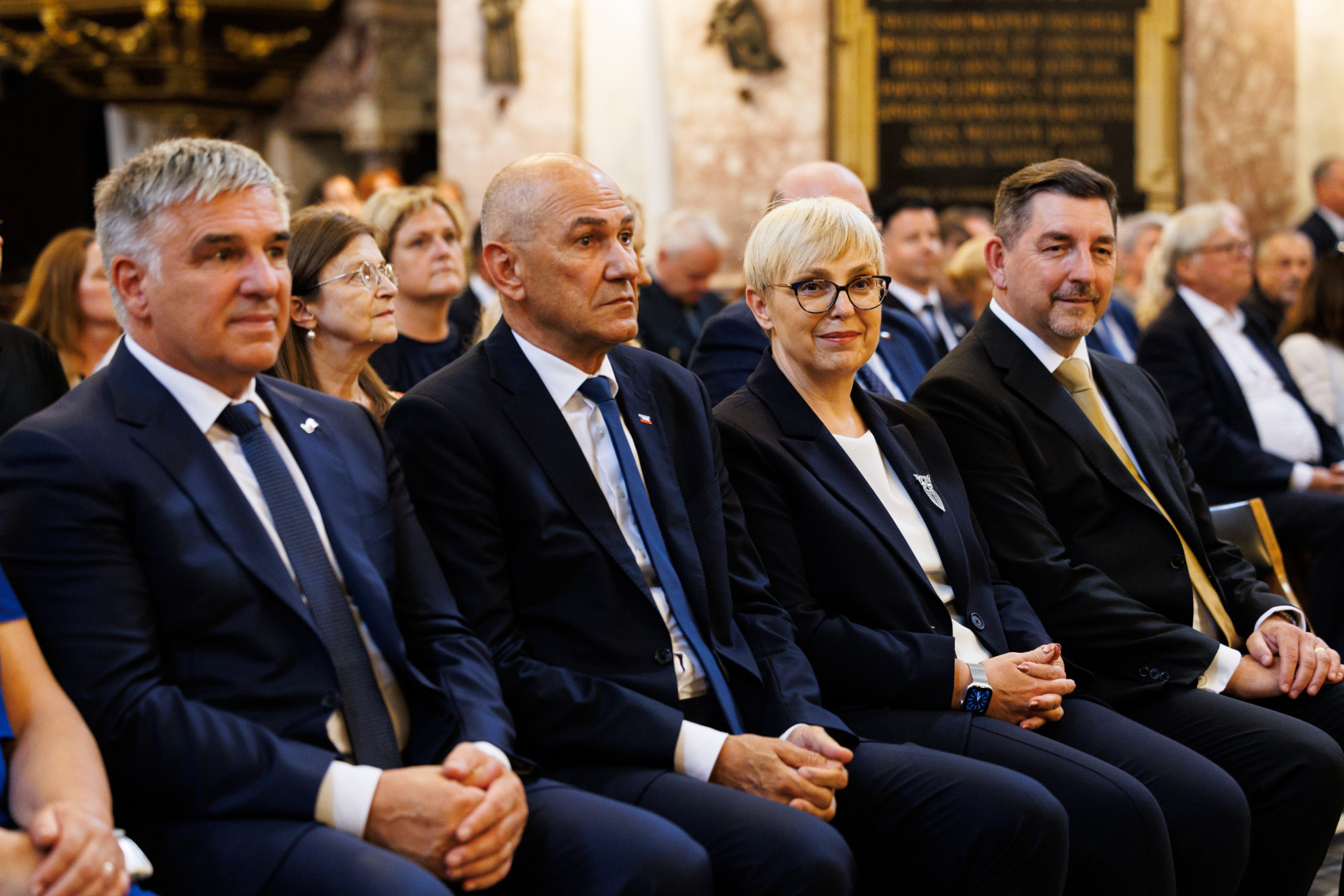 Predsednica in drugi povabljenci sedijo v stolnici in spremljajo sveto mašo.