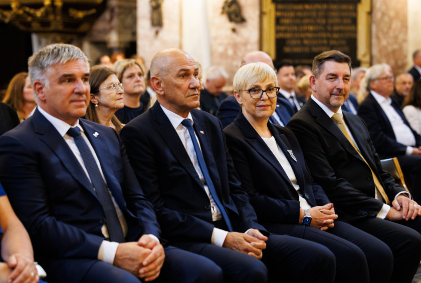 Predsednica in drugi povabljenci sedijo v stolnici in spremljajo sveto mašo.