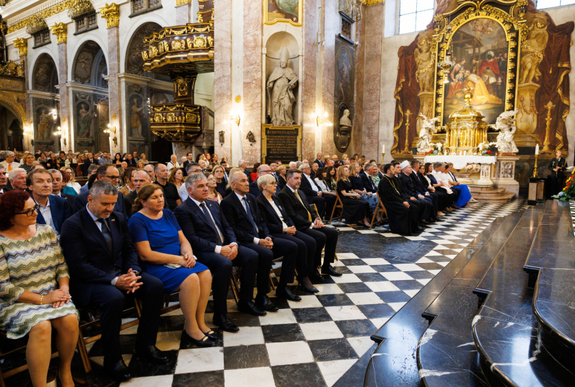 Predsednica in drugi povabljenci sedijo v stolnici in spremljajo sveto mašo.