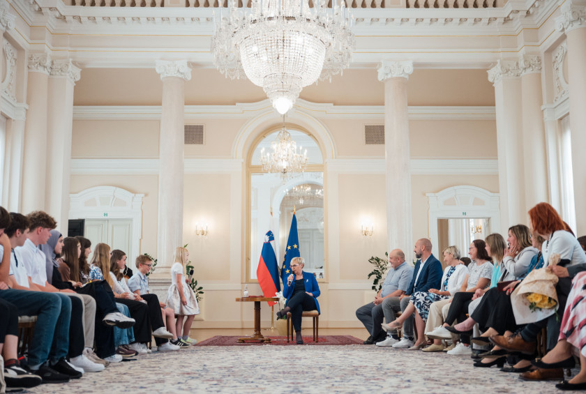 Predsednica na sredini odgovarja na vprašanja osnovnošolcev.