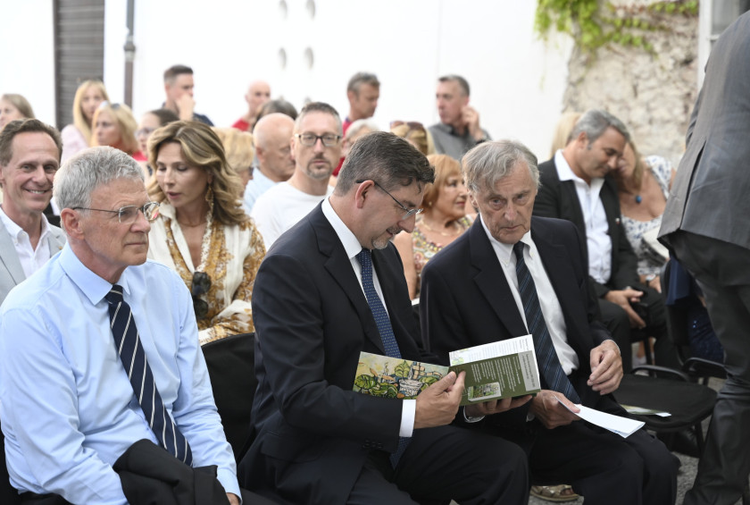 Dr. Musar se pogovarja z gospodom, ki sedi poleg njega.