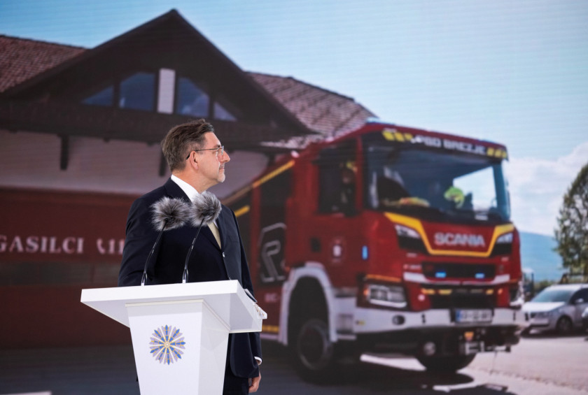 Nastop soproga na mednarodni konferenci, na ozadju je video, ki prikazuje slovensko gasilko vozilo.