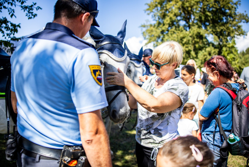 Predsednica republike je pozdravila tudi policiste v Volčjem Potoku. Na fotografiji med božanjem policijskega konja. 