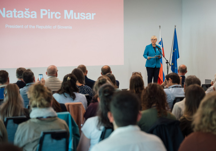 Predsednica stoji na odru in nagovarja zbrane na kongresu.