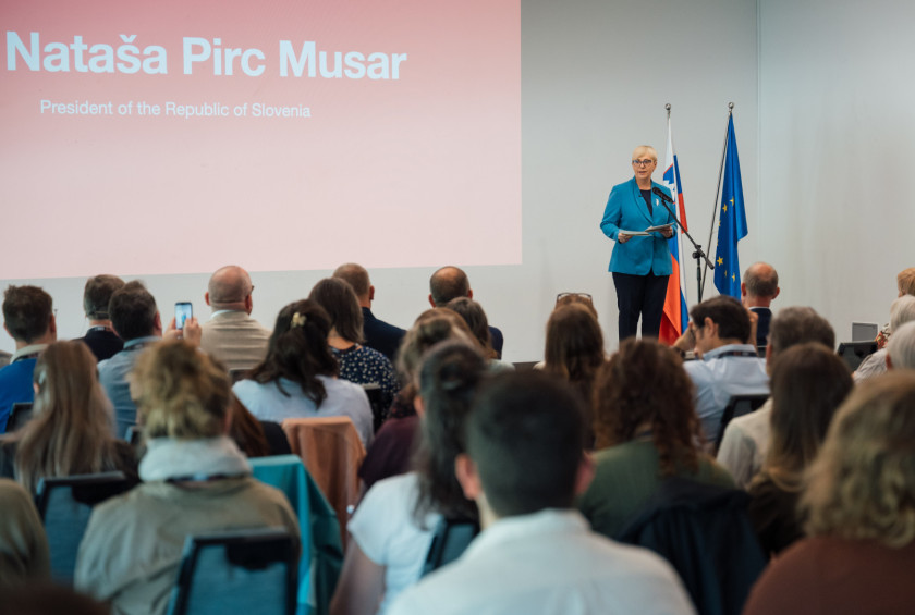 Predsednica stoji na odru in nagovarja zbrane na kongresu.