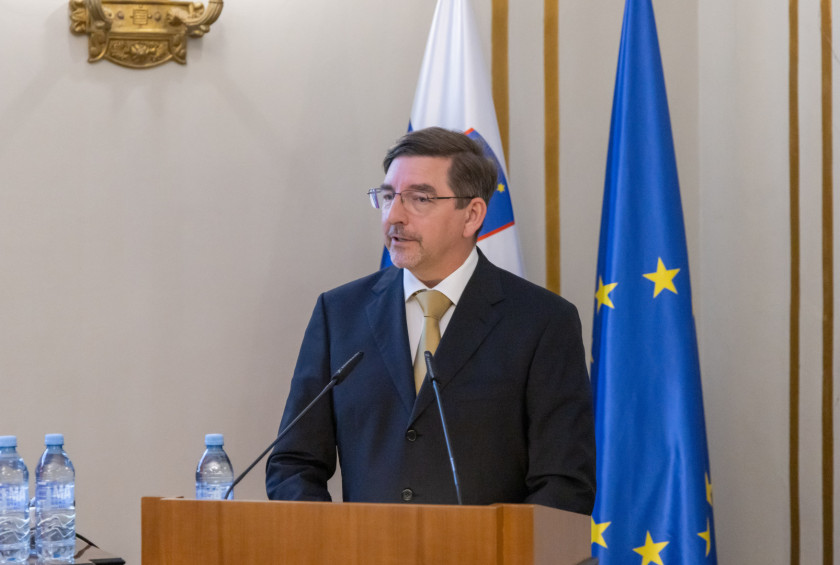 Dr. Aleš Musar govori za govorniškim pultom, v ozadju sta zastavi Slovenije in Evropske unije.